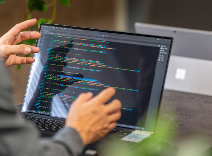 ソースコードがノートPCに映るイメージ画像